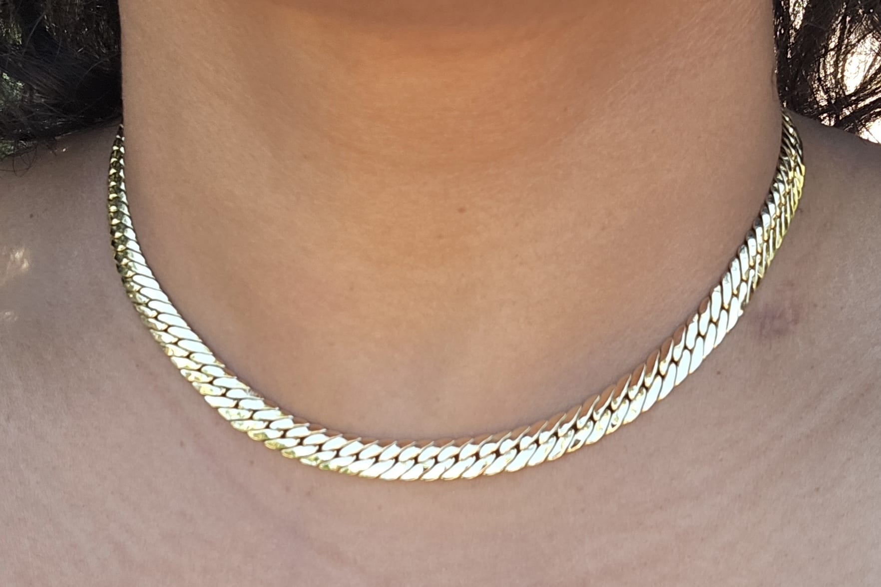 Gold chain necklace on a person's neck
